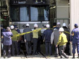 Police examine wrecked subway train car